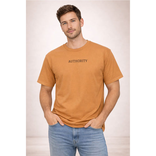 Man wearing a mustard yellow t-shirt with 'AUTHORITY' text on a plain background