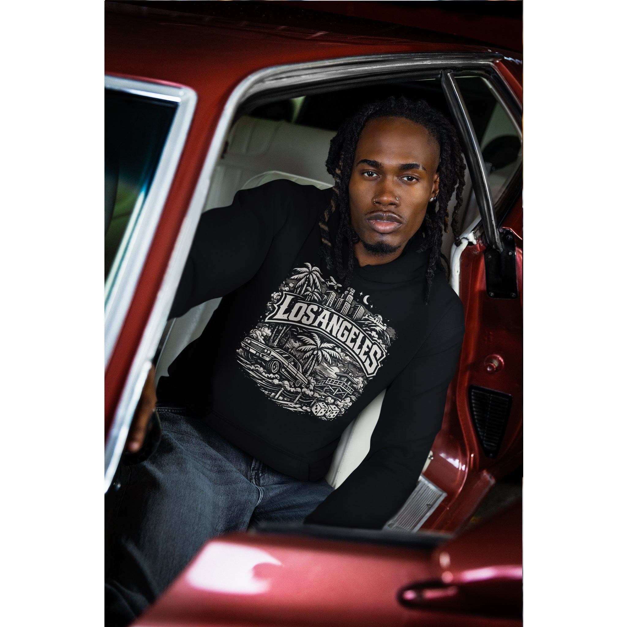 Man sitting inside a red car wearing a black hoodie with 'Los Angeles' text  – Bamerix