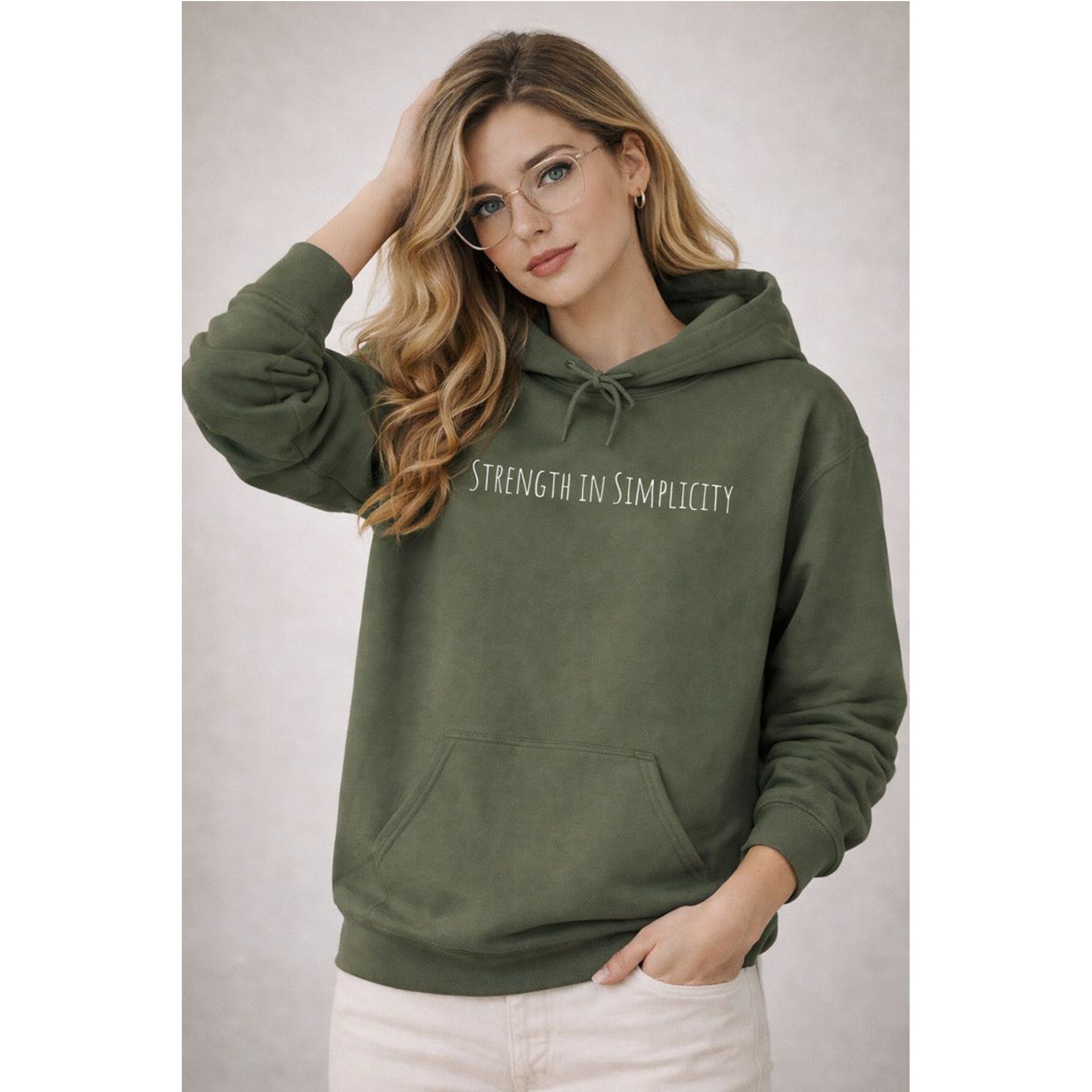 Woman wearing a green hoodie with 'Strength in Simplicity' text on a plain background