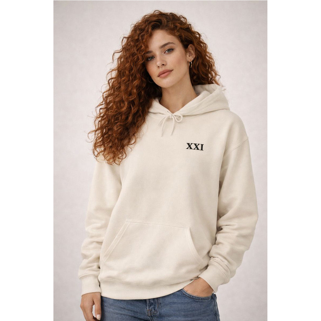 Woman wearing a beige hoodie with 'XXI' logo on a plain background