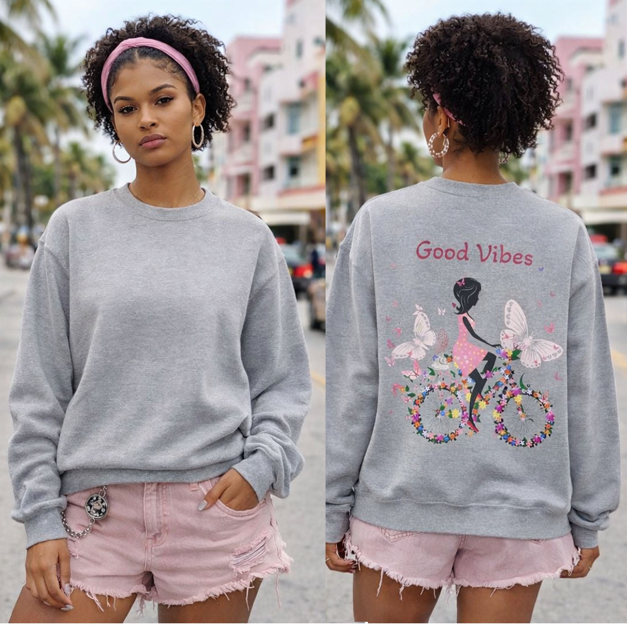 Woman wearing a gray sweatshirt with a graphic design and text, standing on a street.