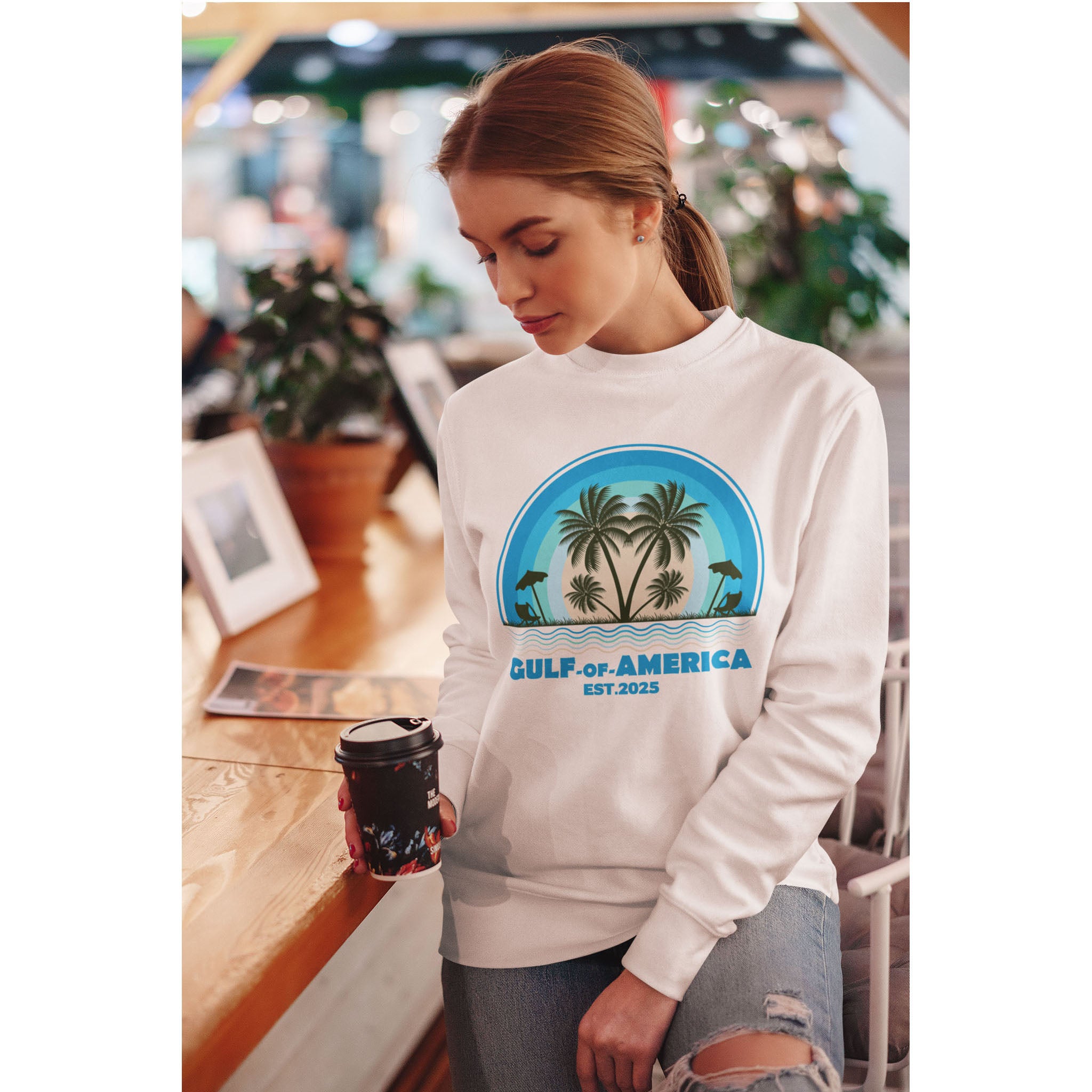 Woman wearing a sweatshirt with a palm tree design in a casual setting