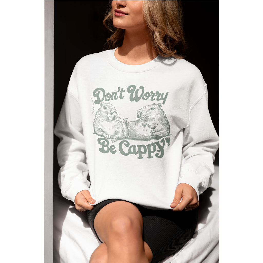 Person wearing a white sweatshirt with a graphic and text 'Don't Worry Be Cappy' on a black background
