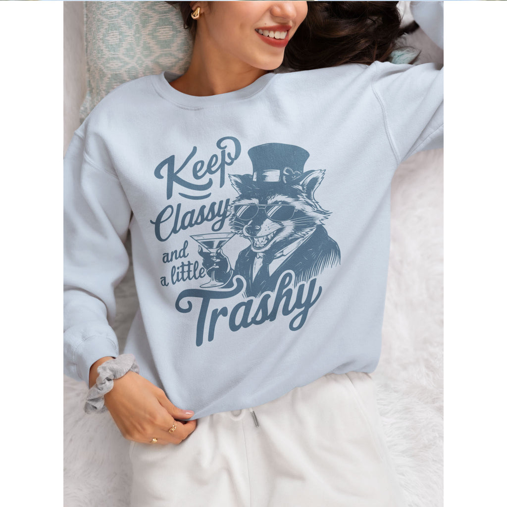 Person wearing a light blue sweatshirt with a graphic and text, sitting on a bed – Bamerix