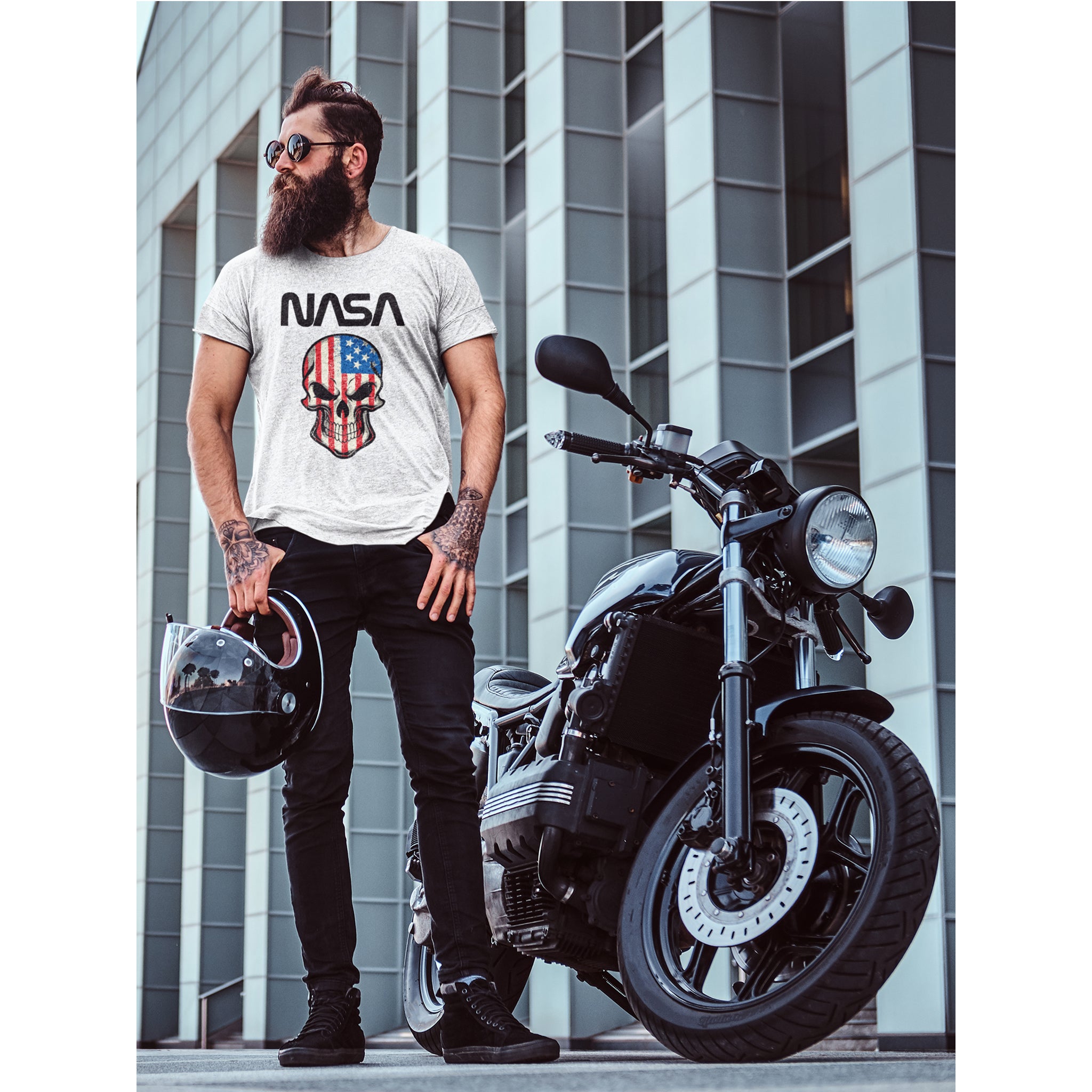 Man wearing a NASA t-shirt with a skull design, standing next to a motorcycle in an urban setting – Bamerix