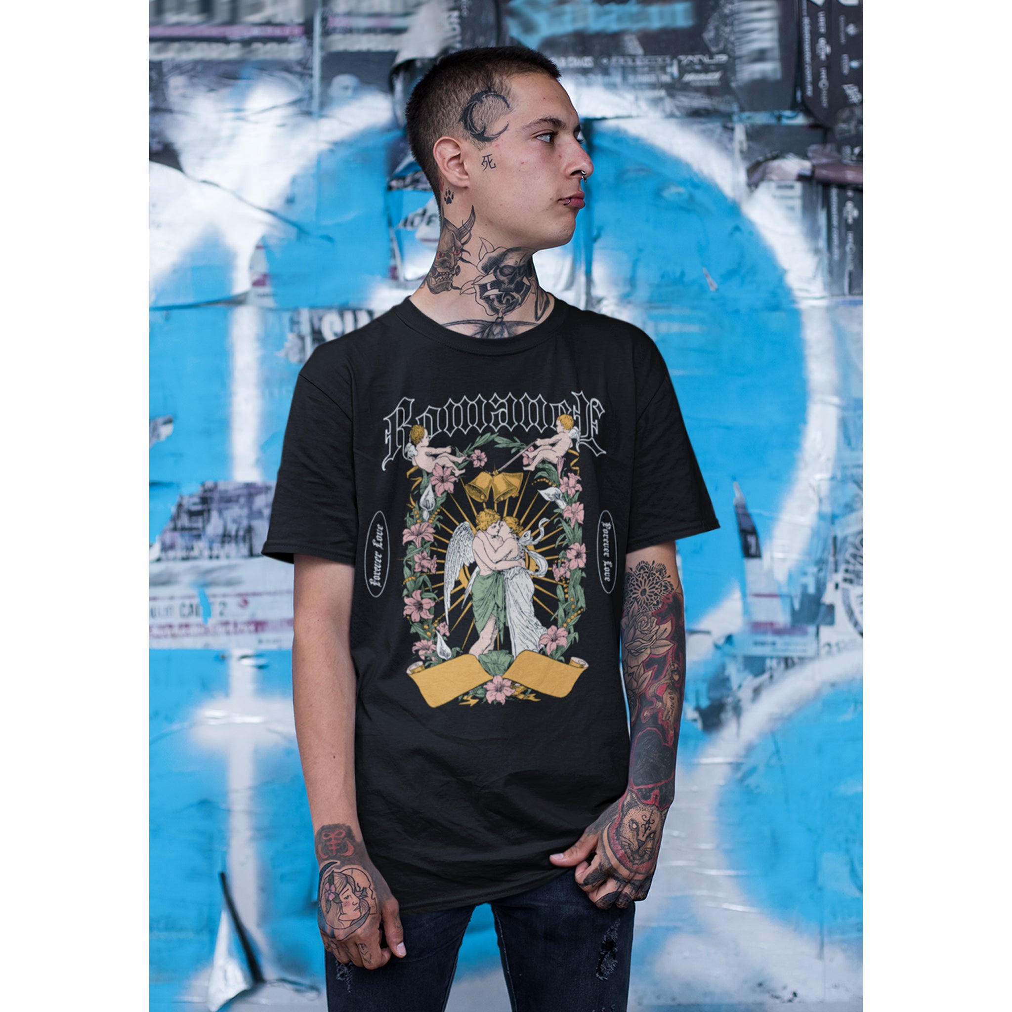 Person wearing a black t-shirt with graphic design in front of a graffiti wall – Bamerix