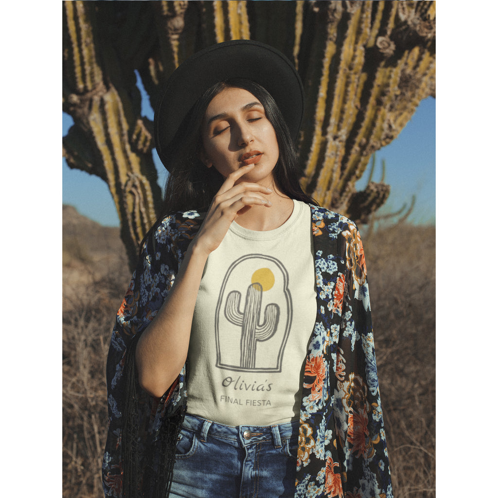 Woman wearing a floral cardigan over a graphic t-shirt with a cactus design, standing in front of a cactus plant.