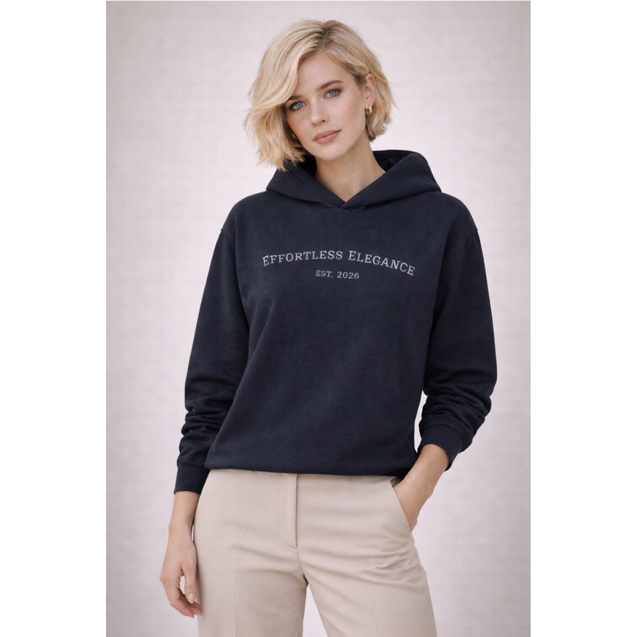 Woman wearing a navy hoodie with 'Effortless Elegance' text on a light gray background