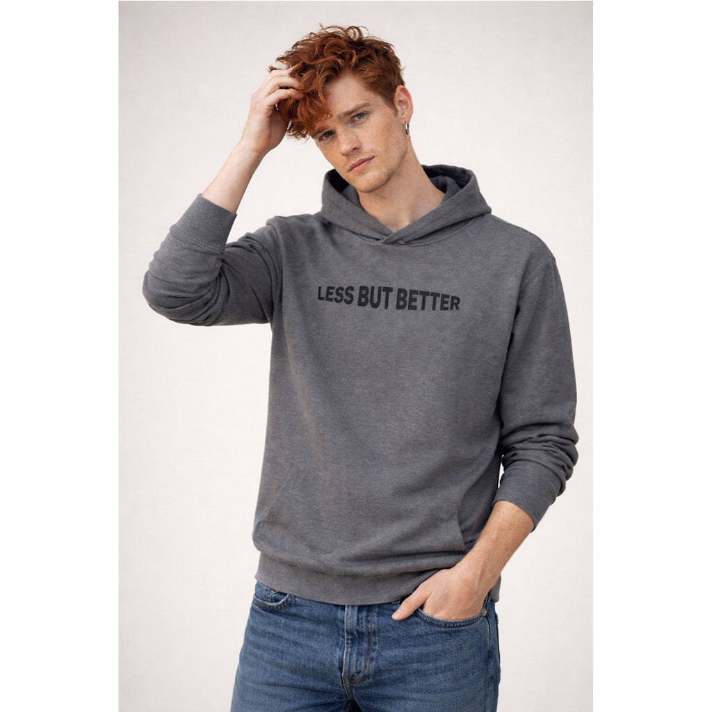 Person wearing a gray hoodie with 'LESS BUT BETTER' text on a plain background