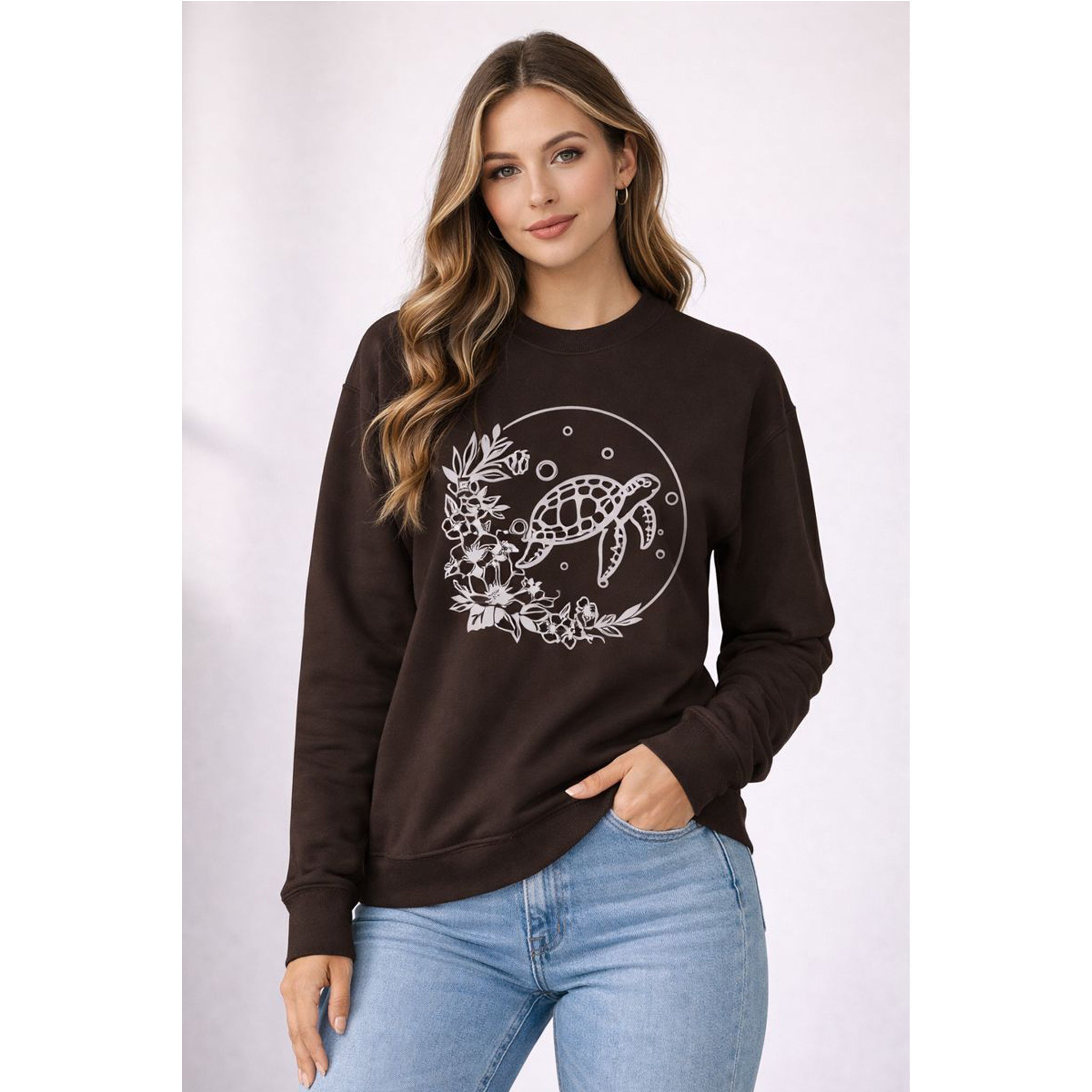 Woman wearing a black sweatshirt with a turtle design on a white background