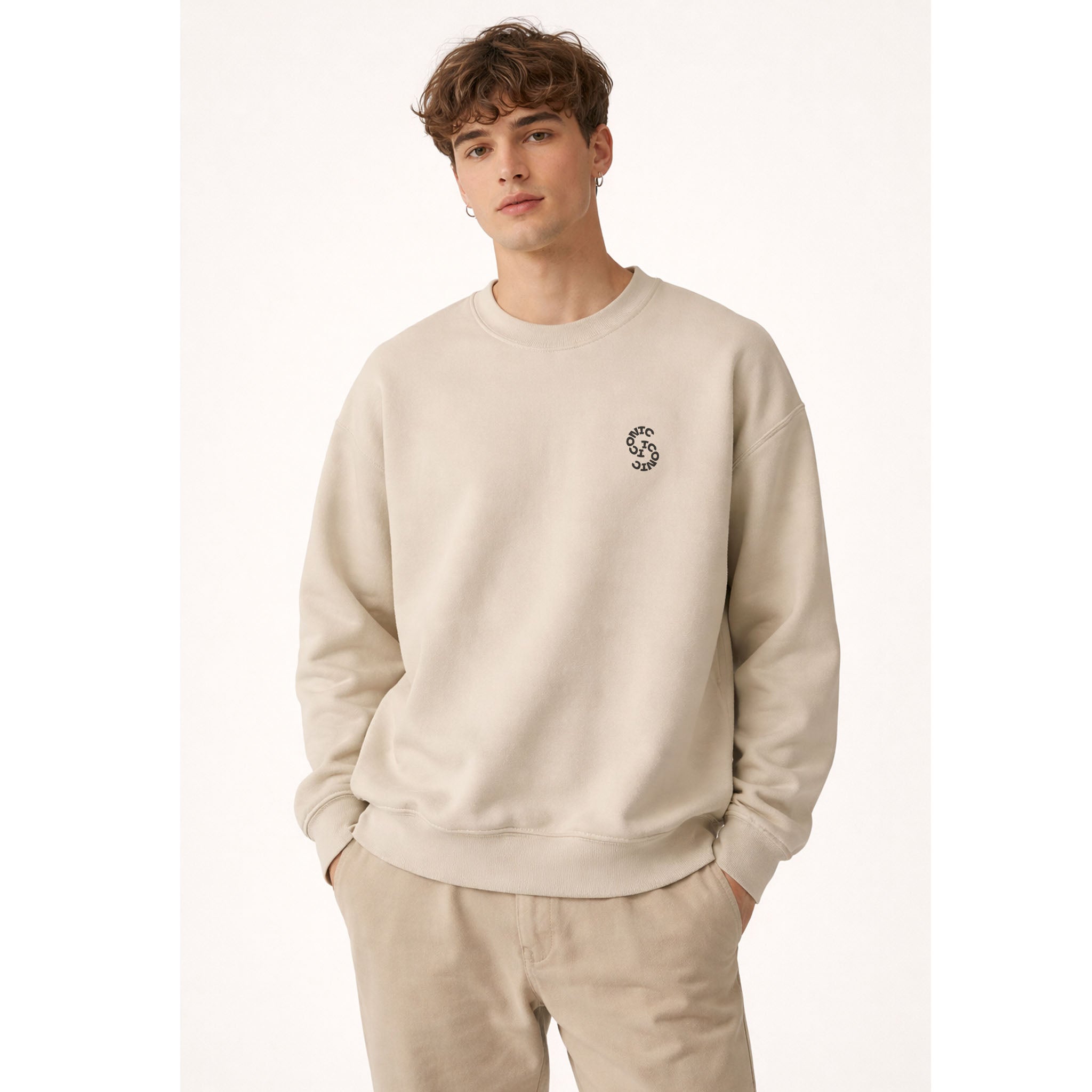 Man wearing a beige sweatshirt with a small logo on a white background