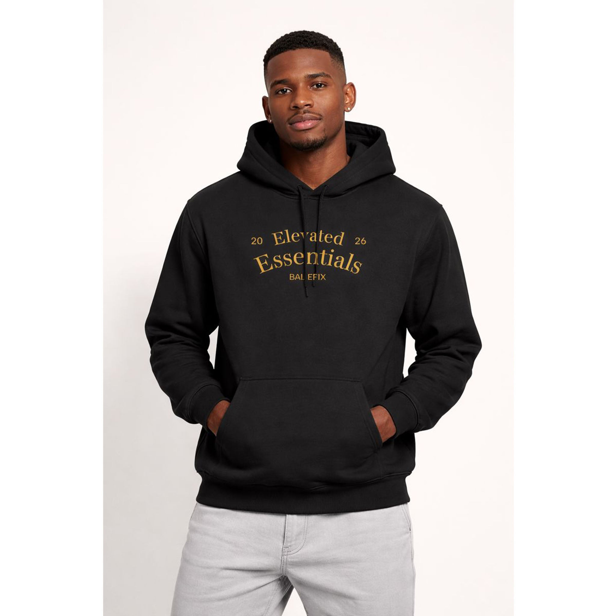 Man wearing a black hoodie with gold text on a white background