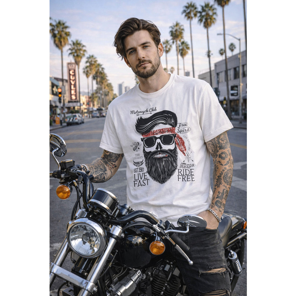 Man wearing a white t-shirt with a graphic design on a motorcycle in an urban setting with palm trees.