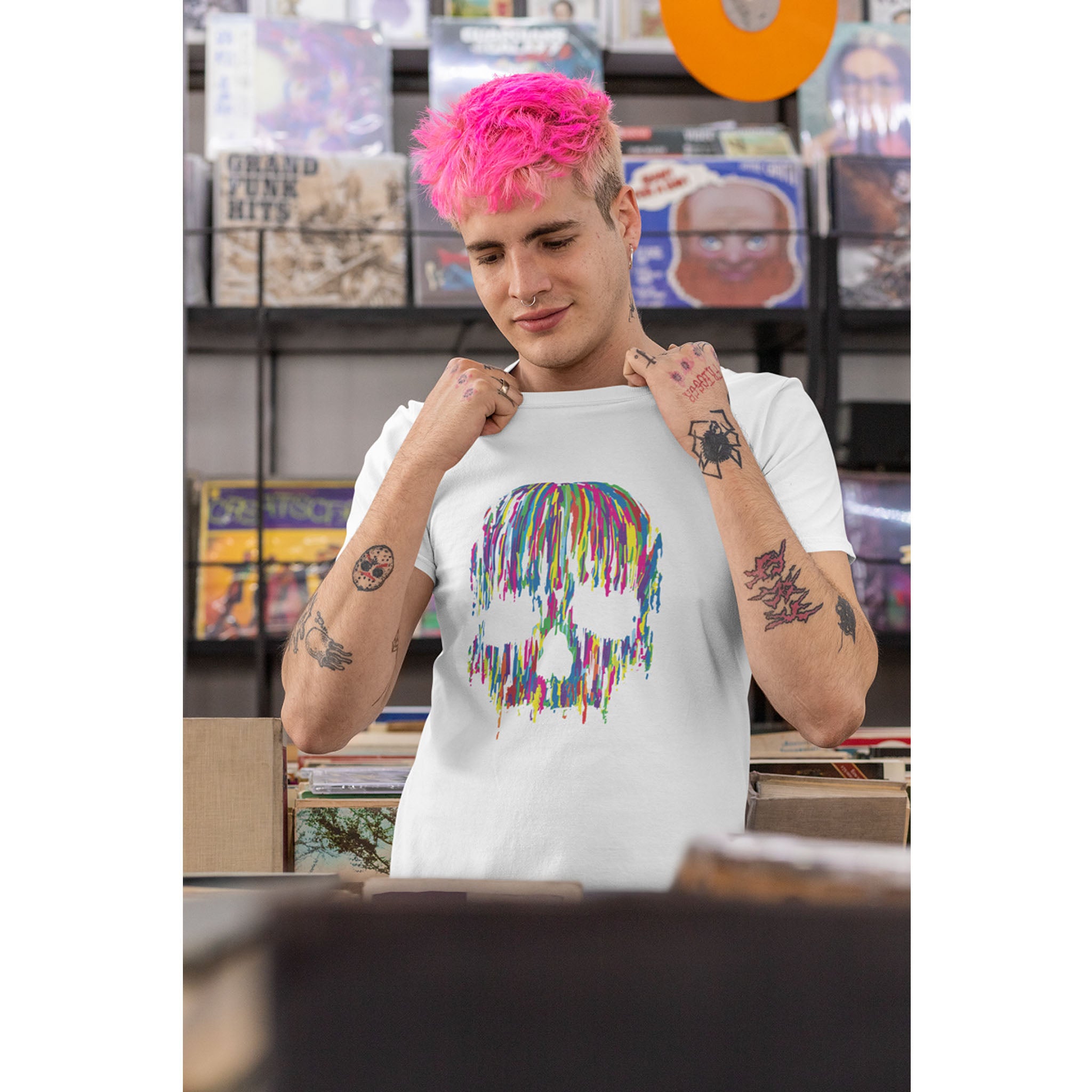 Person wearing a white t-shirt with a colorful skull design in a store setting.