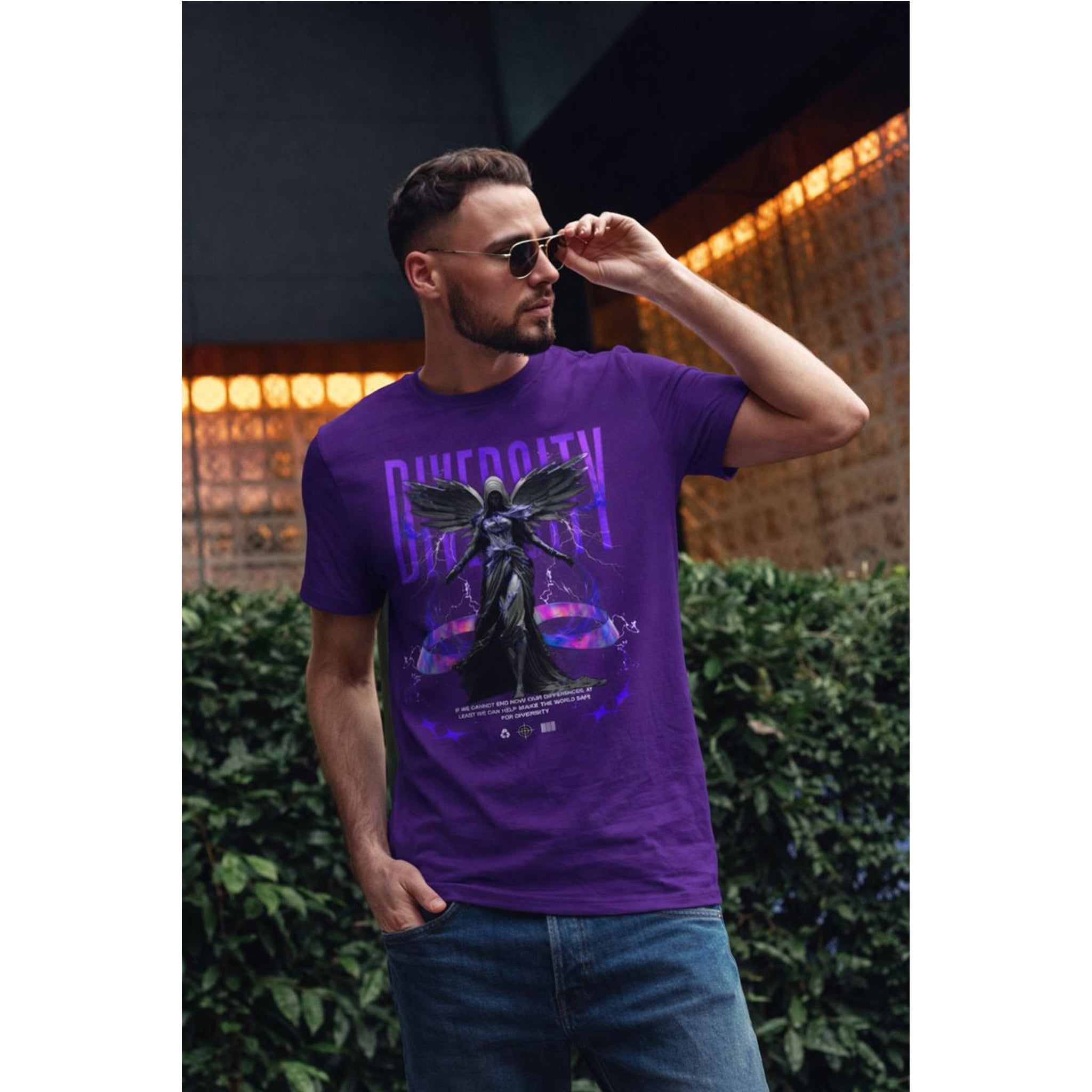 Man wearing a purple graphic t-shirt with sunglasses outdoors.