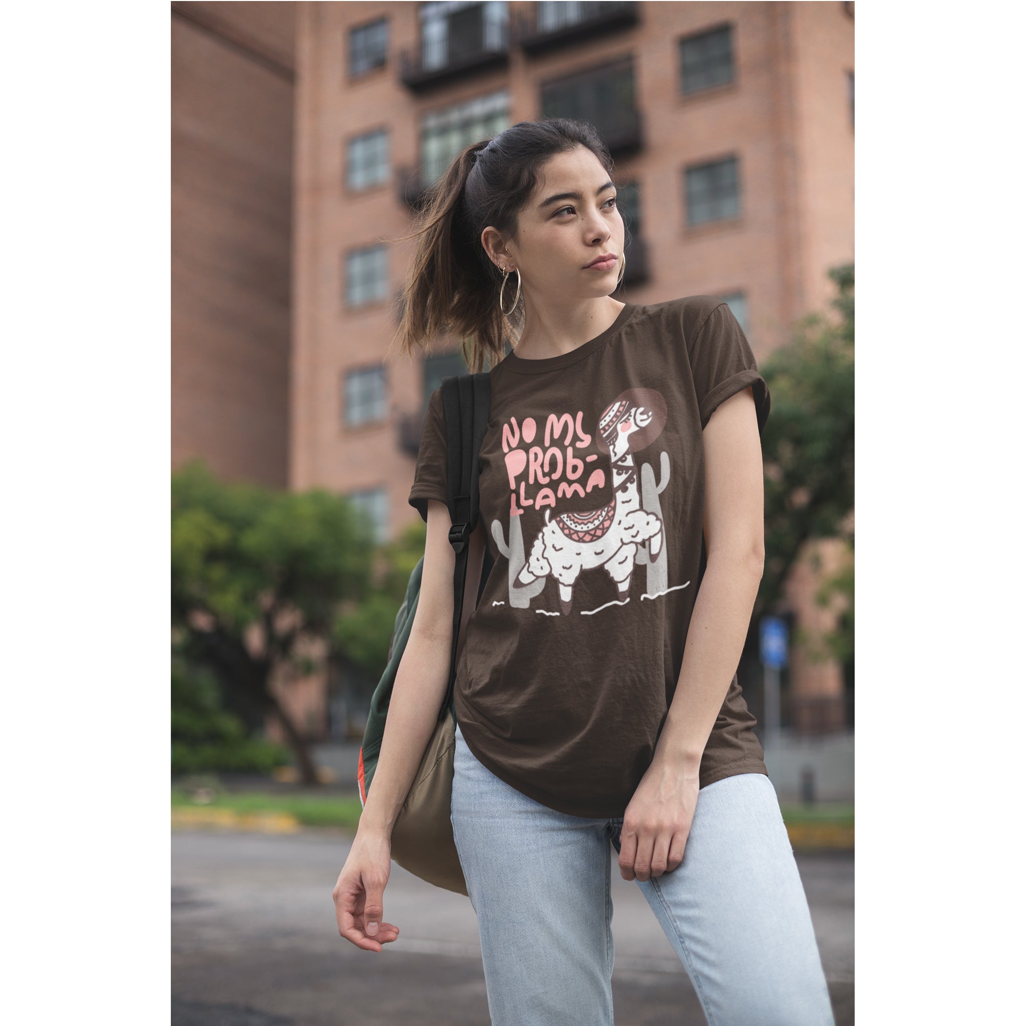Woman wearing a brown t-shirt with graphic design outdoors
