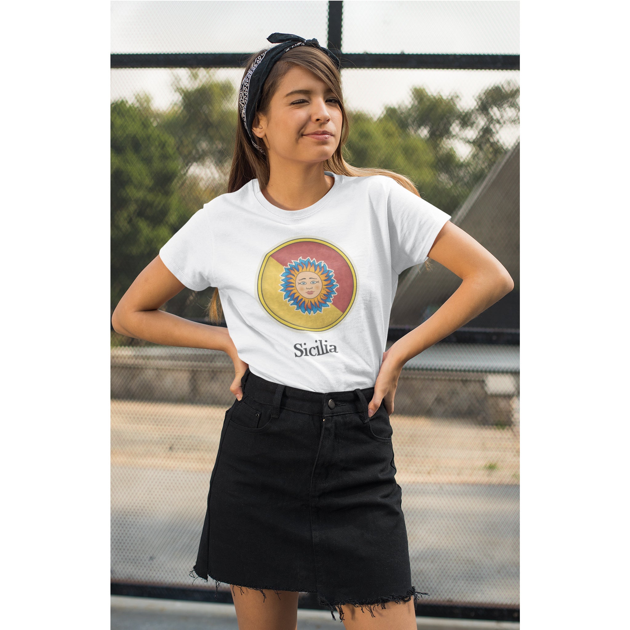 Person wearing a white t-shirt with a colorful design and text, standing outdoors.