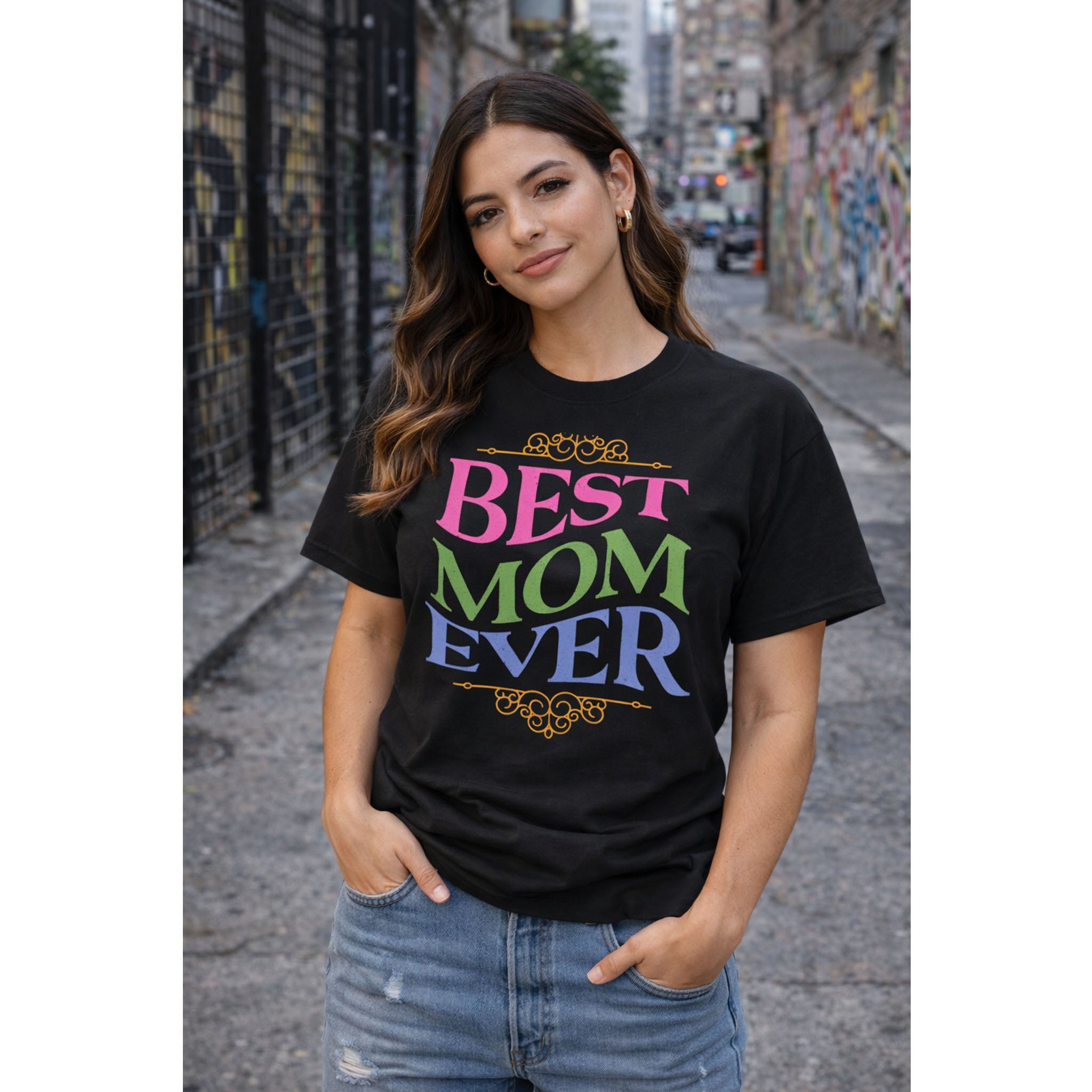 Woman wearing a black t-shirt with 'BEST MOM EVER' text in colorful letters on a street.