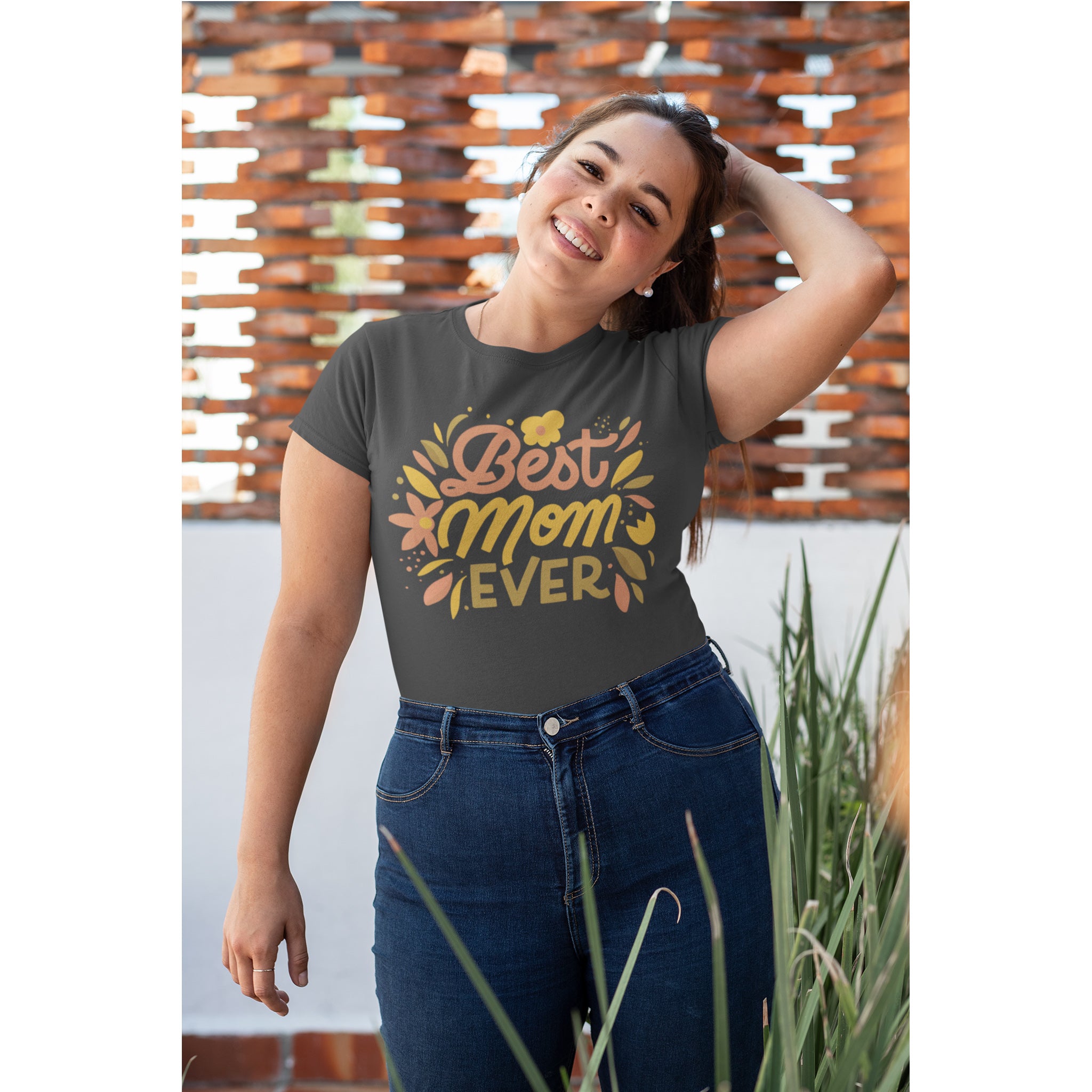 Woman wearing a gray t-shirt with 'Best Mom Ever' text and floral design, standing outdoors.