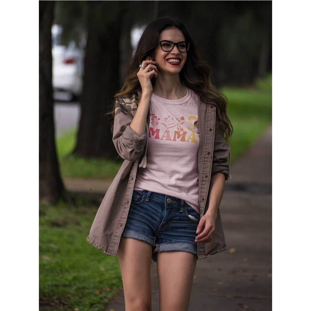 Woman in a park wearing a 'MAMA' t-shirt and denim shorts.