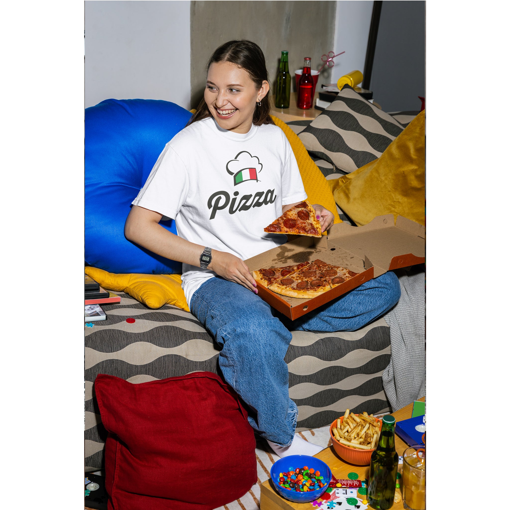 Person sitting on a colorful couch with pizza and drinks, wearing a 'Pizza' t-shirt.