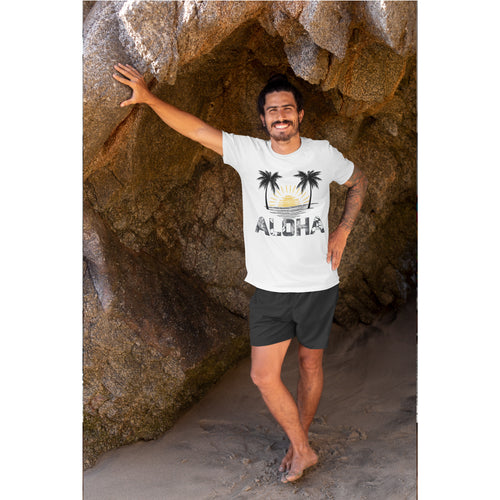 Man wearing a white t-shirt with a palm tree design and 'Aloha' text, standing in a rocky cave.