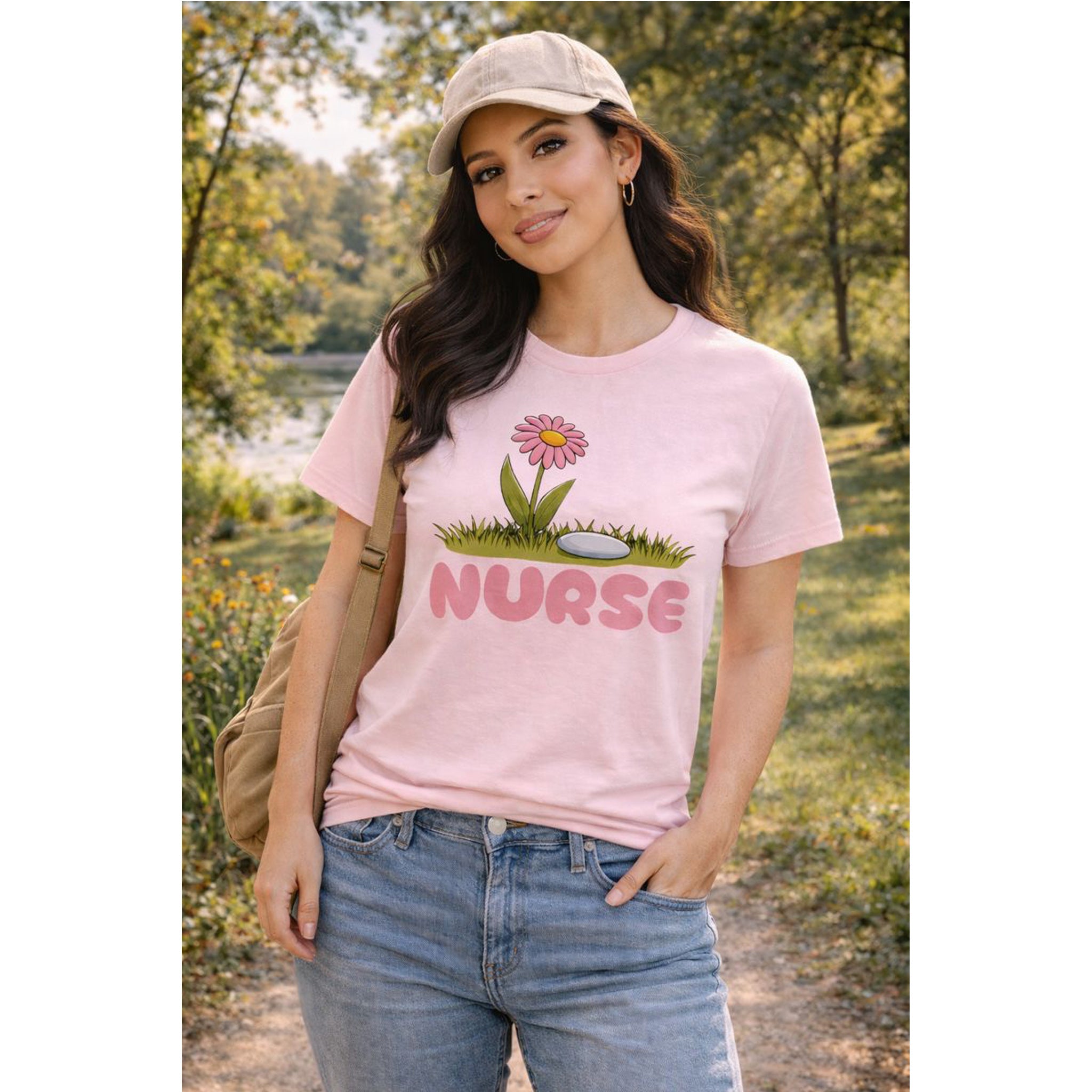 Woman wearing a pink 'NURSE' t-shirt with a daisy graphic outdoors.