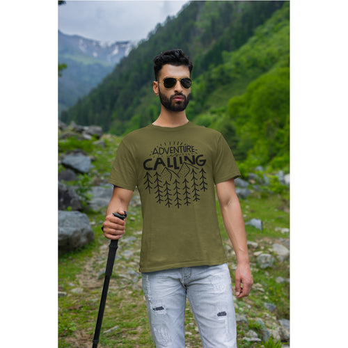 Man wearing a green t-shirt with 'Adventure Calling' text in a mountainous landscape