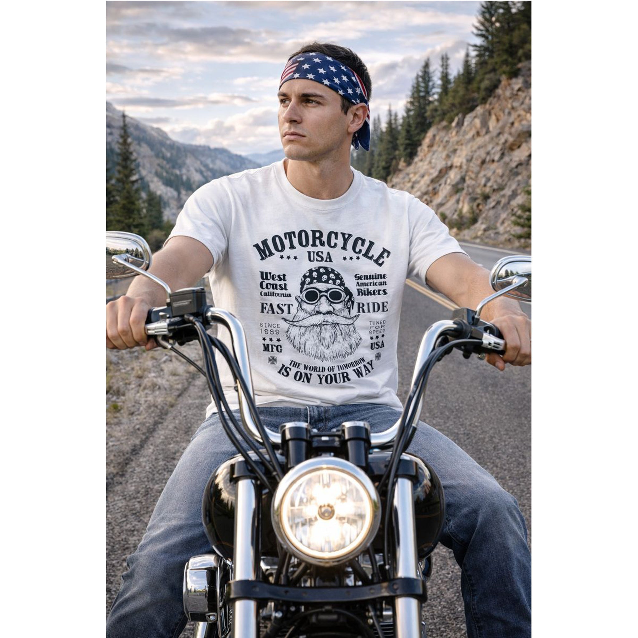 Man riding a motorcycle on a scenic road wearing a t-shirt with a motorcycle graphic.