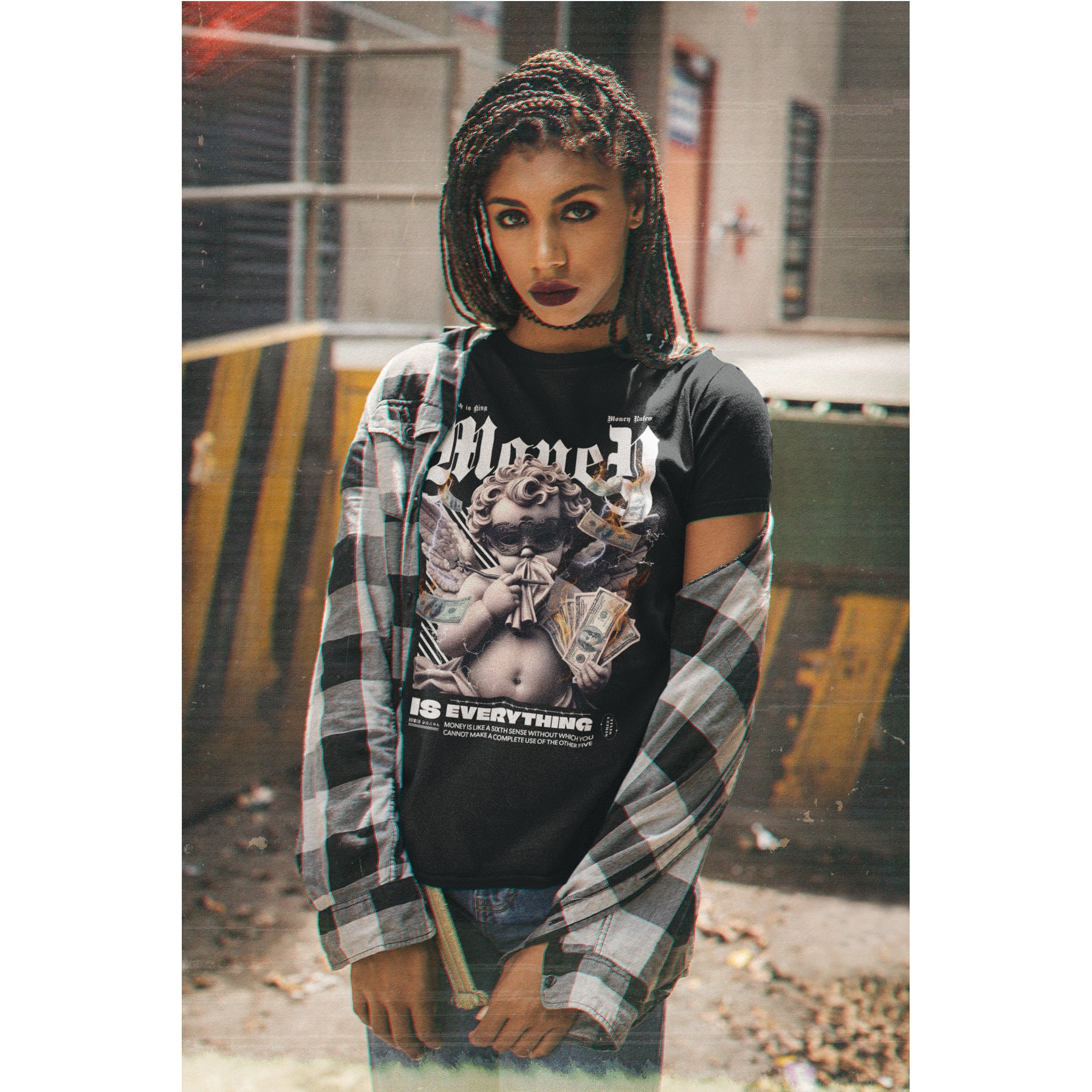 Person wearing a black graphic t-shirt with plaid shirt over it, standing in an urban setting.