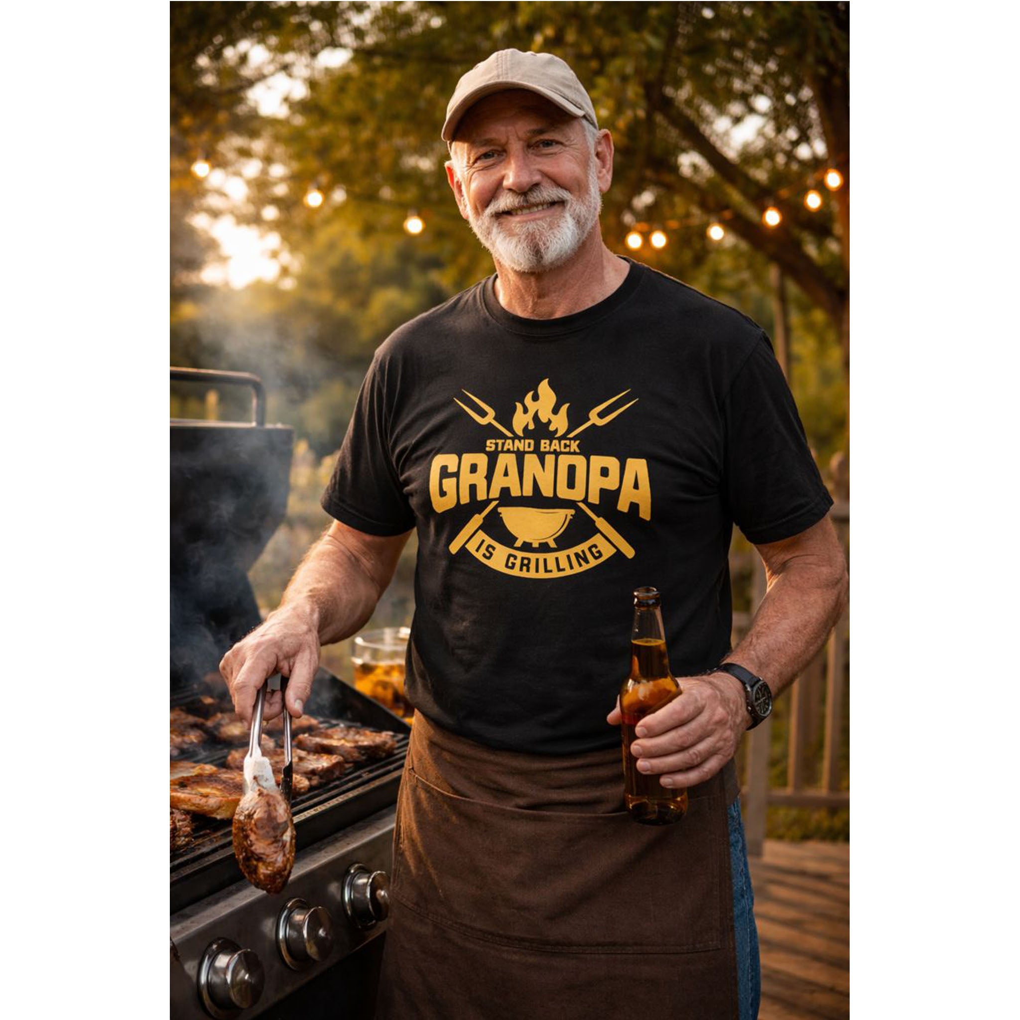 bamerix Man wearing a 'Grandpa is Grilling' t-shirt, holding a beer and a skewer, standing next to a grill outdoors.