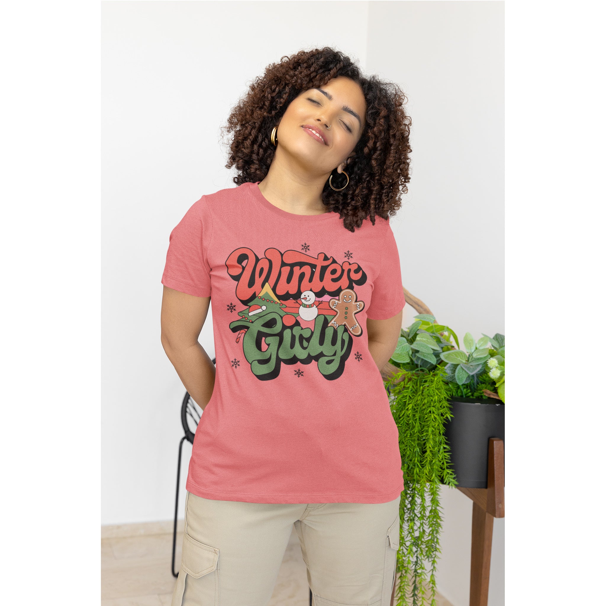 Woman wearing a pink t-shirt with 'Winter Girl' text, standing indoors.