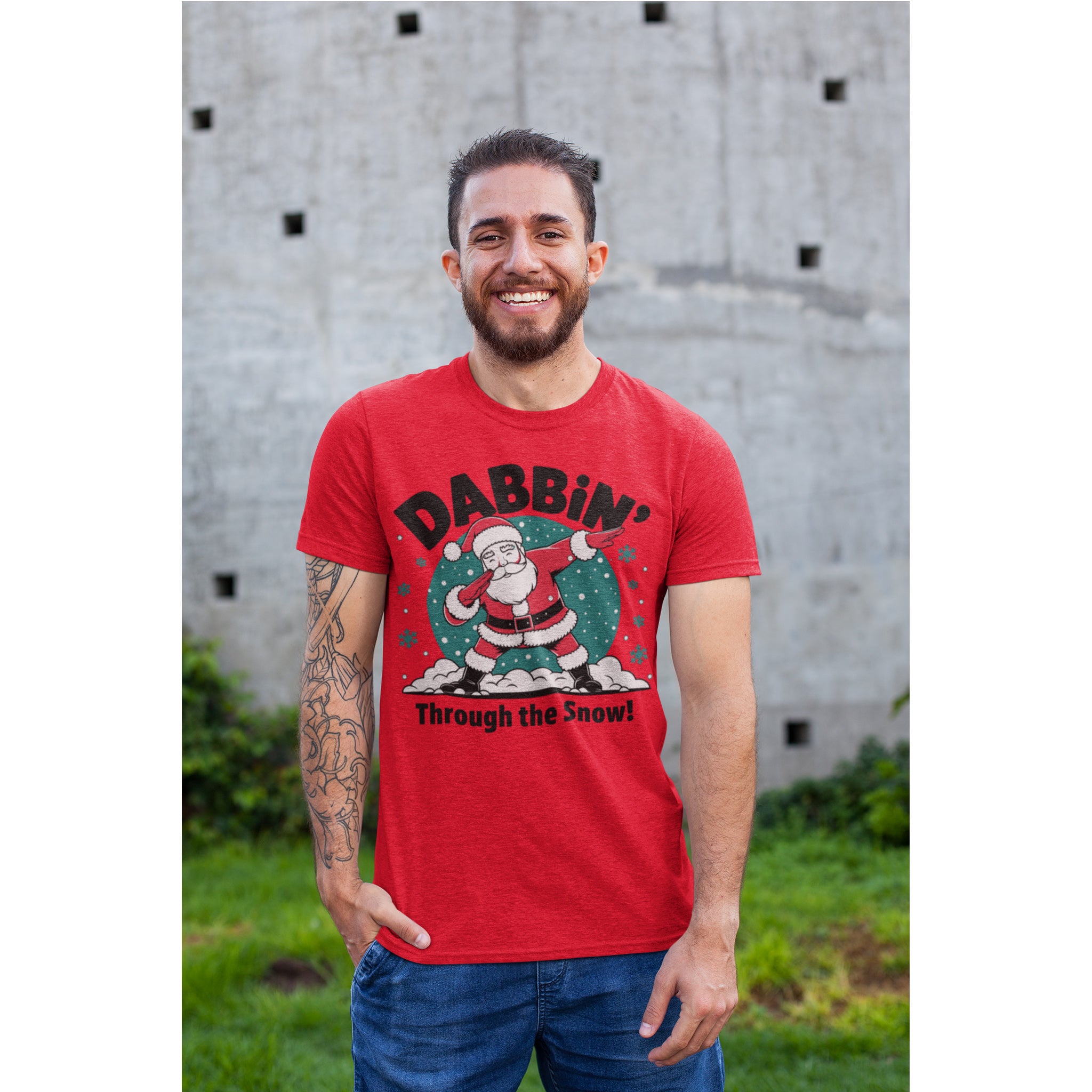 Man wearing a red t-shirt with a Christmas design of Santa Claus and text, standing outdoors.