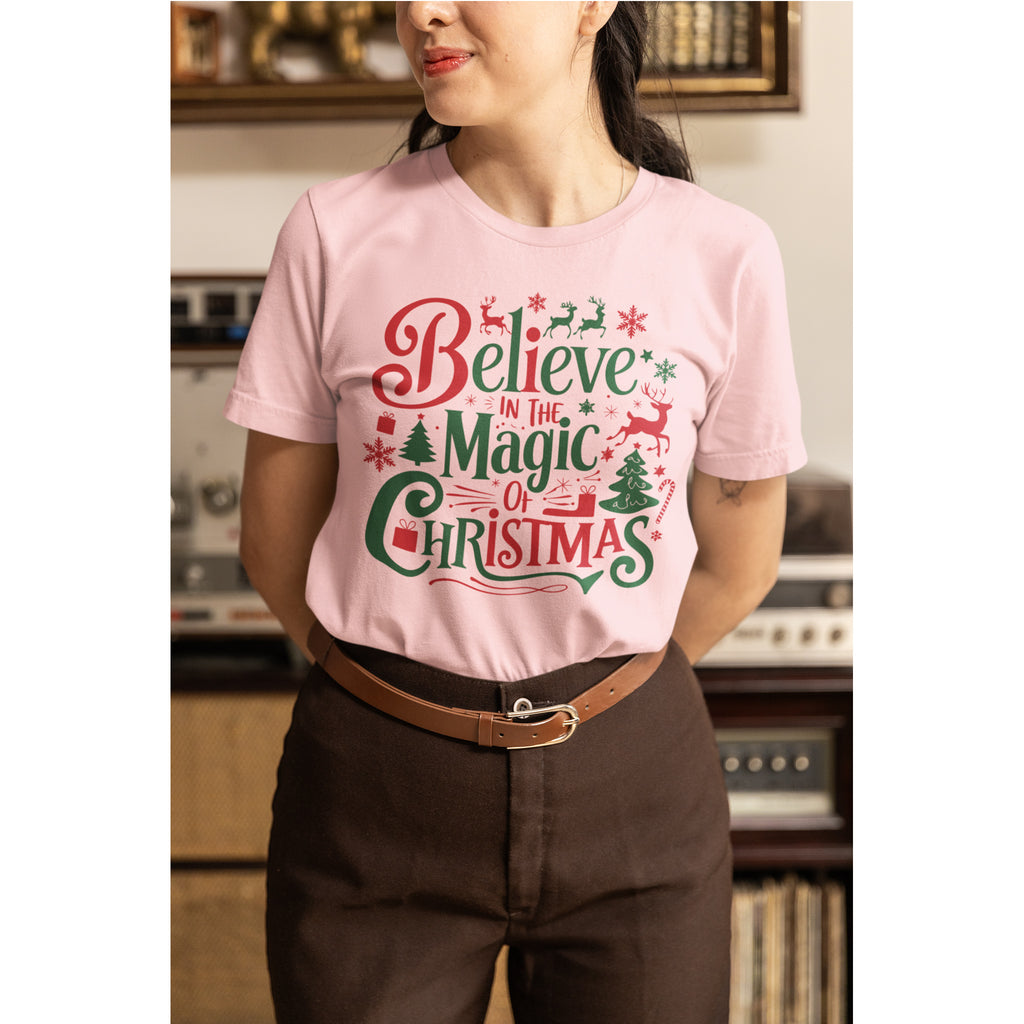 Person wearing a pink t-shirt with Christmas-themed text in a room.