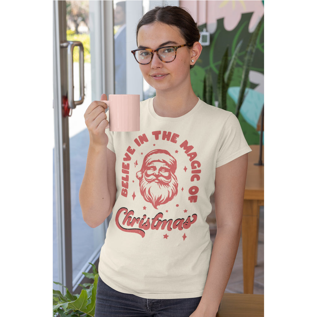 Person wearing a t-shirt with Christmas design holding a mug.